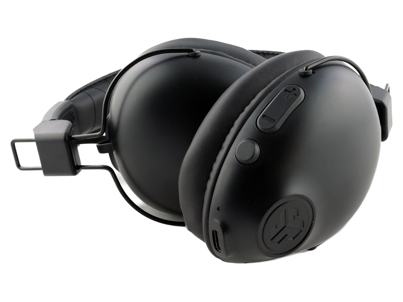 JLab Studio Pro Wireless Over-Ear Kopfhörer Schwarzer Over-Ear-Kopfhörer mit dick gepolsterten Ohrpolstern, verstellbarem Kopfbügel und Bedientasten an der Seite, die auf einer schlichten weißen Oberfläche ruhen.